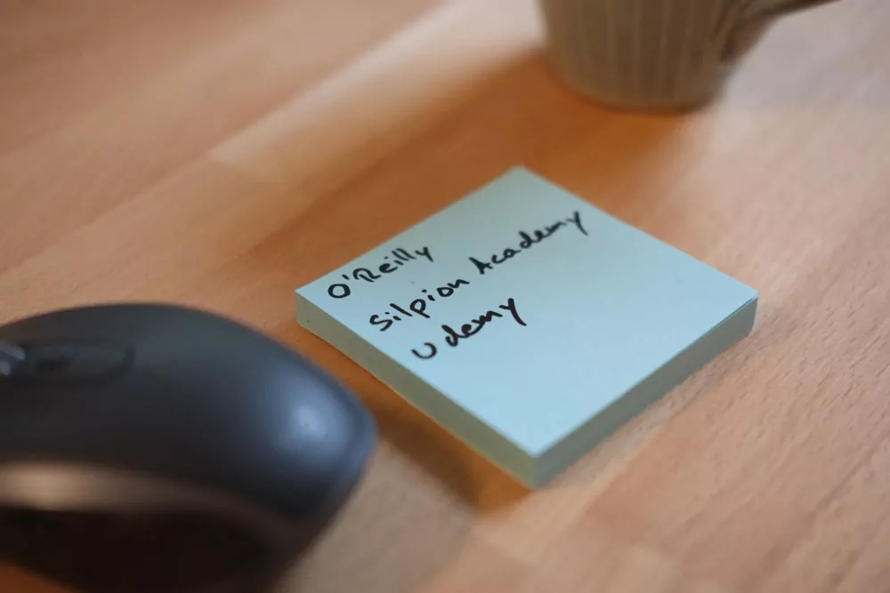 Notizzettel mit O'Reilly, Silpion Academy und Udemy neben einer Computermaus