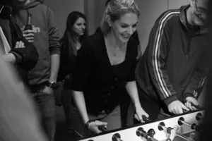 Schwarz-Weiß-Foto: lachende Spielerin am Kickertisch beim Silpion Kicker Cup 2016
